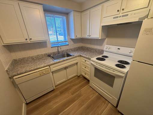 A kitchen with white appliances and cabinets.