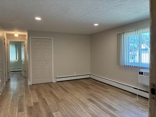 A room with wooden flooring and a window.