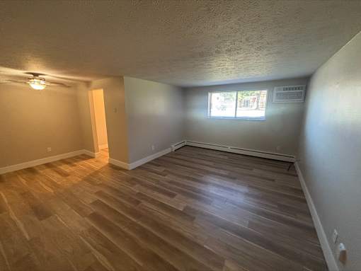 A room with wooden flooring and a window.