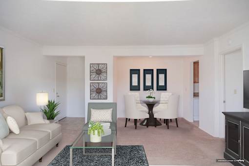 A living room with a sofa, a table with a vase of flowers, and a television at Hummingbird Pointe & The Gardens, Parma, 44129