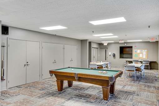 A pool table in a room with a carpeted floor and white walls at Independence Place Apartments, Parma Heights, OH 44130