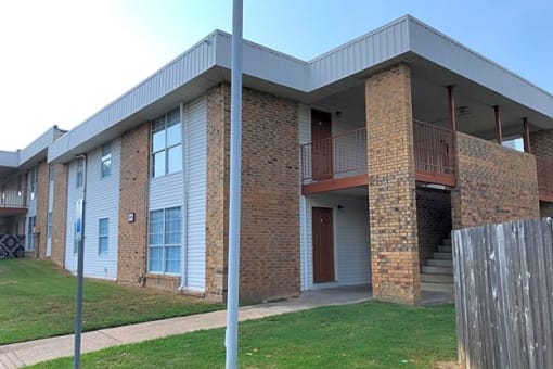 an image of a brick apartment building with a porch