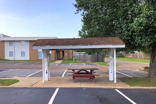 a picnic table in a parking lot in front of a building