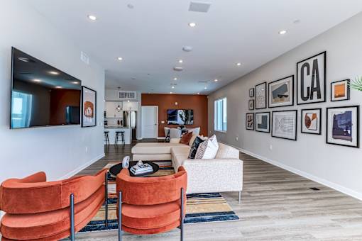 A living room with orange chairs and a white couch.