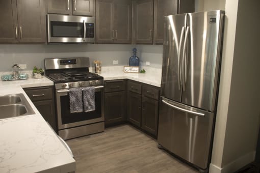 a kitchen with gray cabinets and stainless steel appliances at The Crossings at Redlands, California, 92374