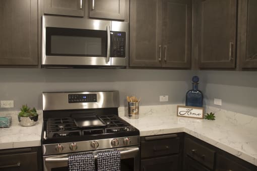 a kitchen with a stove and a microwave at The Crossings at Redlands, California, 92374