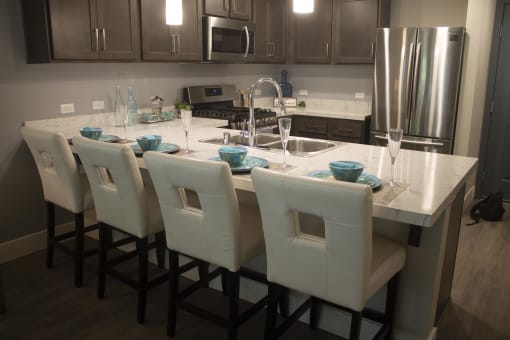 a kitchen with a large island with a marble countertop at The Crossings at Redlands, Redlands, CA, 92374