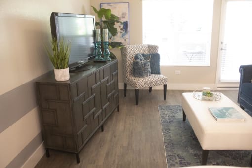 a living room with a tv and a chair at The Crossings at Redlands, Redlands, CA