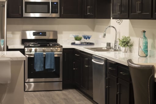 a kitchen with black cabinets and stainless steel appliances at The Crossings at Redlands, Redlands