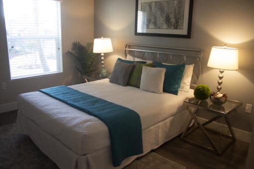 a bedroom with a bed and two lamps  The Crossings at Redlands, California, 92374