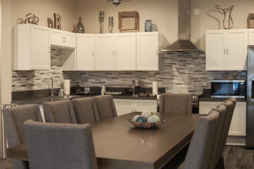 a kitchen with white cabinets and a wooden table with a bowl of eggs on it at The Crossings at Redlands, California