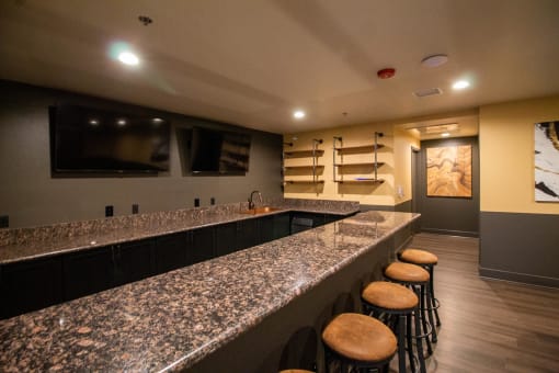 a basement bar with stools and a television at The Crossings at Redlands, California, 92374