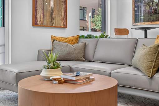 Living room with gray sectional and round coffee table at Sol Apartments, Troy, NY 12180
