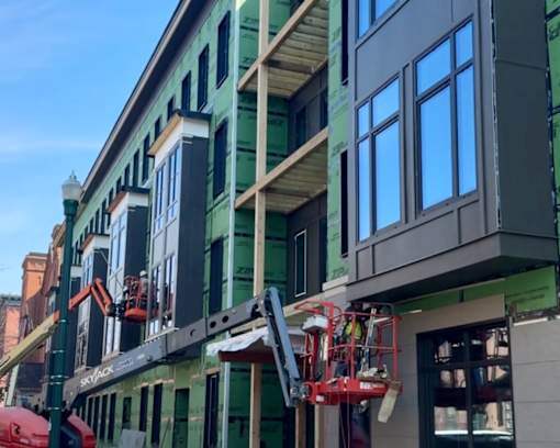 A building under construction with scaffolding and a crane at Sol Apartments, Troy, 12180