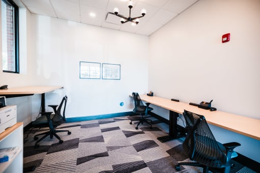 Resident coworking lounge with ergonomic chairs and powered sit-stand desks.