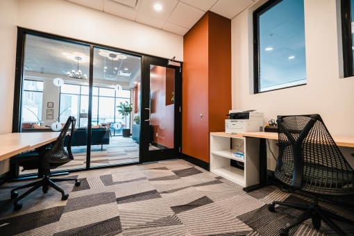 Resident coworking lounge with ergonomic chairs and powered sit-stand desks.