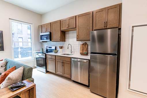 A kitchen with a refrigerator, oven, and microwave.