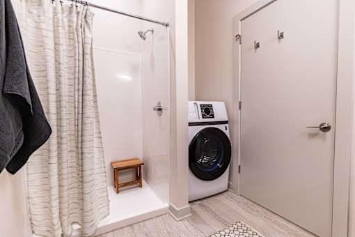 A white bathroom with a washer and dryer in it.