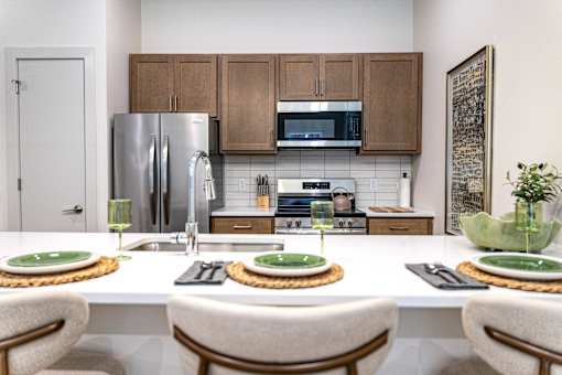 A kitchen with a table set for two with green plates.