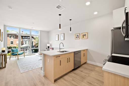 an open kitchen and living room with a sliding glass door to a patio
