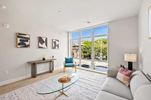 a living room with a couch and a chair and a large window