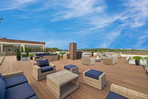 a roof top patio with furniture and a blue sky