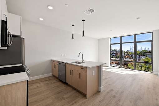 an open kitchen and living room with a view of the city