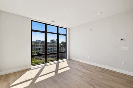 a living room with a large window and wooden floors