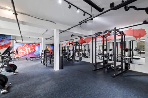 a gym with weights machines and ads on the wall