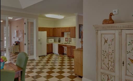A kitchen with a checkered floor and wooden cabinets.