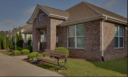 A brick house with a bench in front of it.