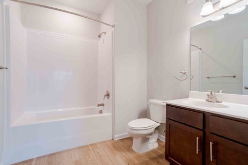 A white bathroom with a toilet, sink, and bathtub.