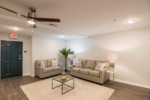 A living room with two couches, a coffee table, and a ceiling fan. at Bickerstaff Crossing Apartments, Virginia, 23231