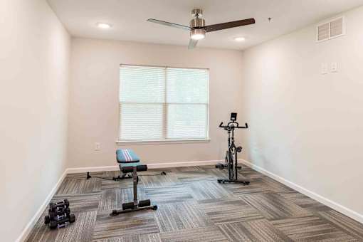 A room with a ceiling fan, a window, and exercise equipment. at Bickerstaff Crossing Apartments, Henrico