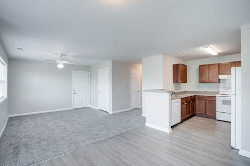 A spacious kitchen with white appliances and wooden cabinets.