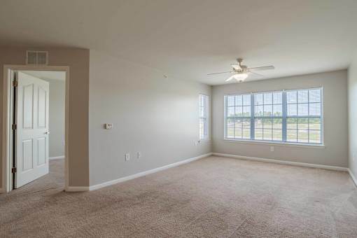 A room with a ceiling fan and a door at Carriage Hills, Lumberton, 28358
