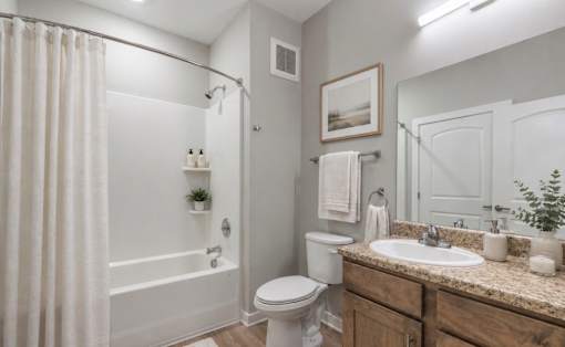 A white bathroom with a toilet, sink, and shower.