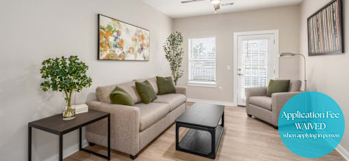 A living room with a couch, a coffee table, and a painting on the wall.