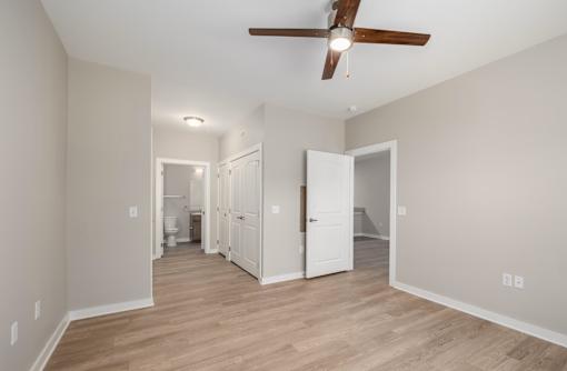 A room with a ceiling fan and wooden floors.