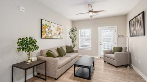 A living room with a couch, a coffee table, and a painting on the wall.