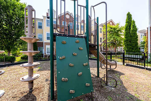 A playground with a green slide and a climbing frame.