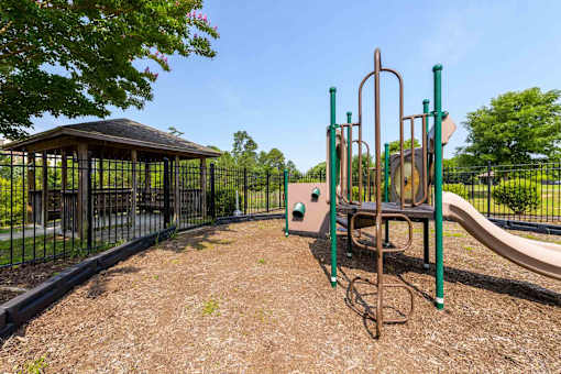 A playground with a slide, swings, and a gazebo.