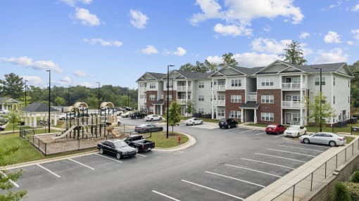 an aerial view of an apartment complex with a playground and parking lot