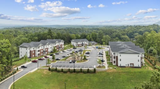 an aerial view of an apartment complex with a parking lot