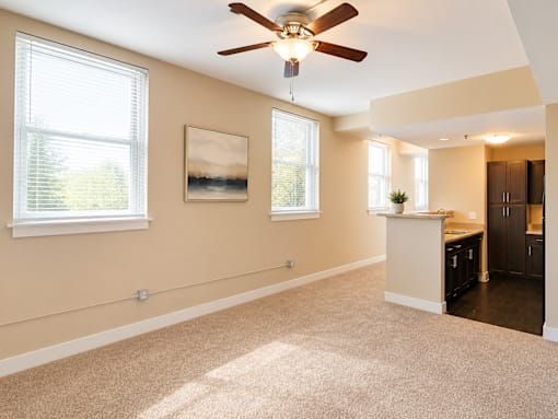 A room with a ceiling fan and a painting on the wall.