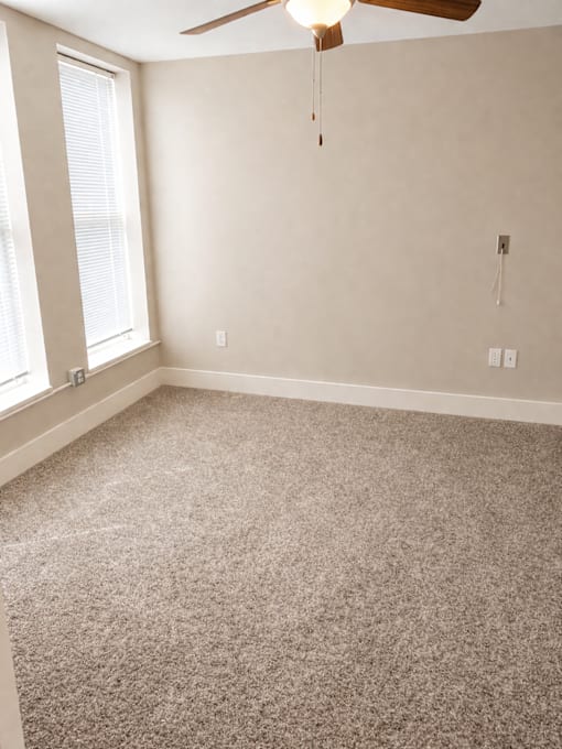 A room with a ceiling fan and a window.