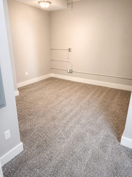 A room with a carpeted floor and white walls.