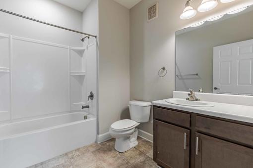 A white bathroom with a toilet, sink, and bathtub. at Killian Terrace Apartments, Columbia