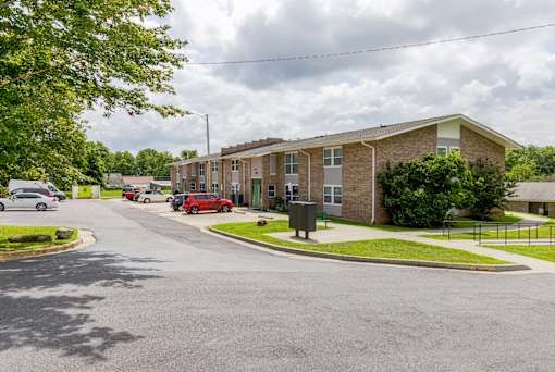 A street view of a residential area with houses and cars.