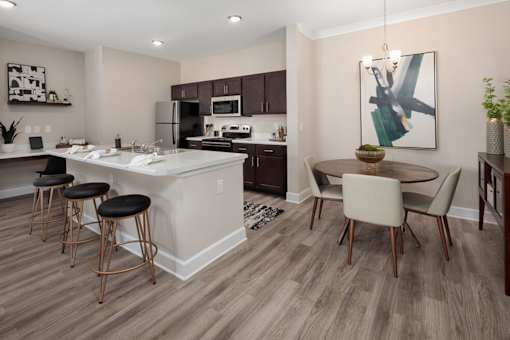 A modern kitchen with a bar area and a dining table.at Summerville Garden, Summerville, 29483